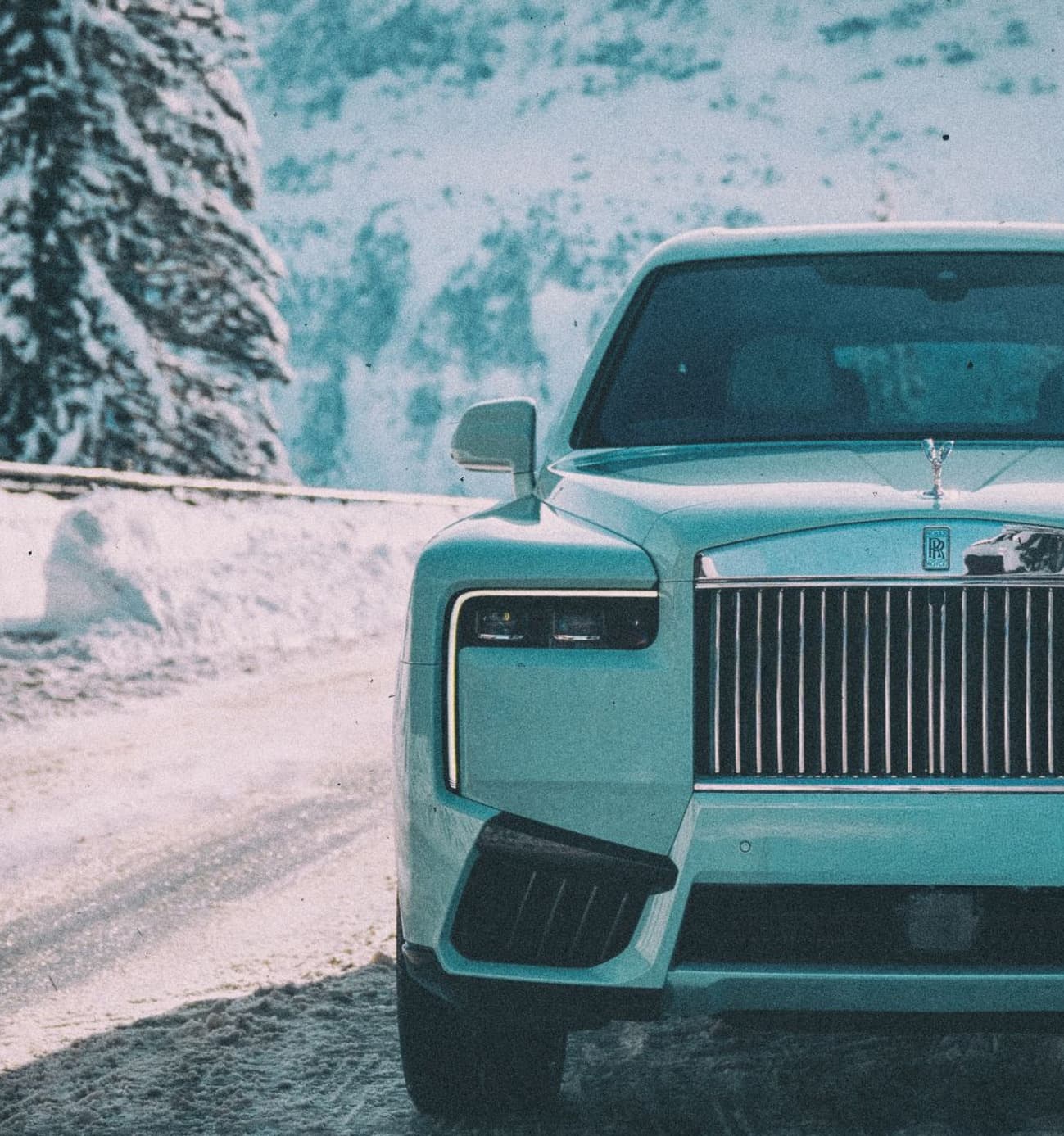 Glacier-blue Rolls-Royce on a snow-covered road