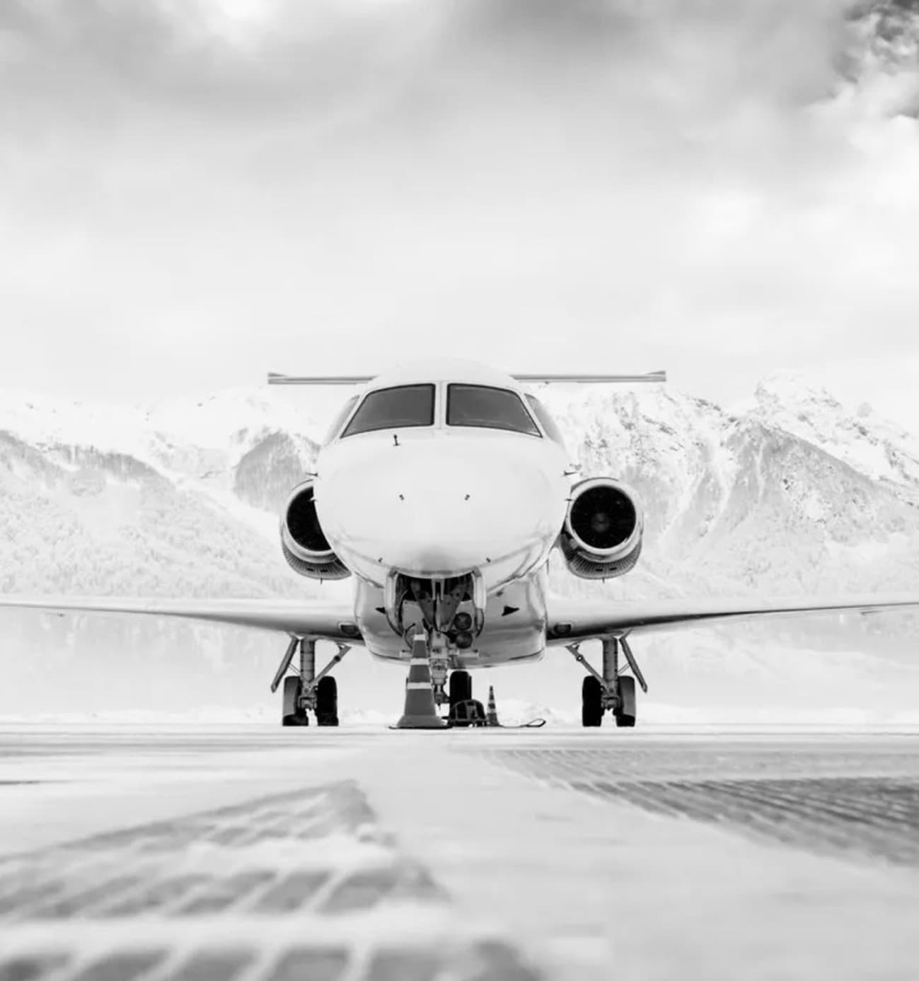 Private jet on the altiport tarmac, snow-capped mountains